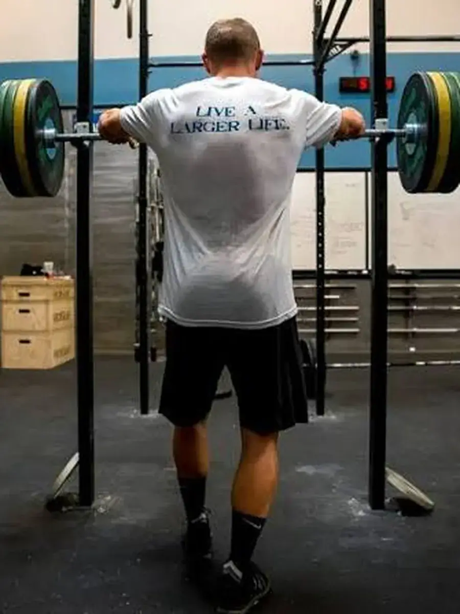A coach training at the rack in an OPEX shirt